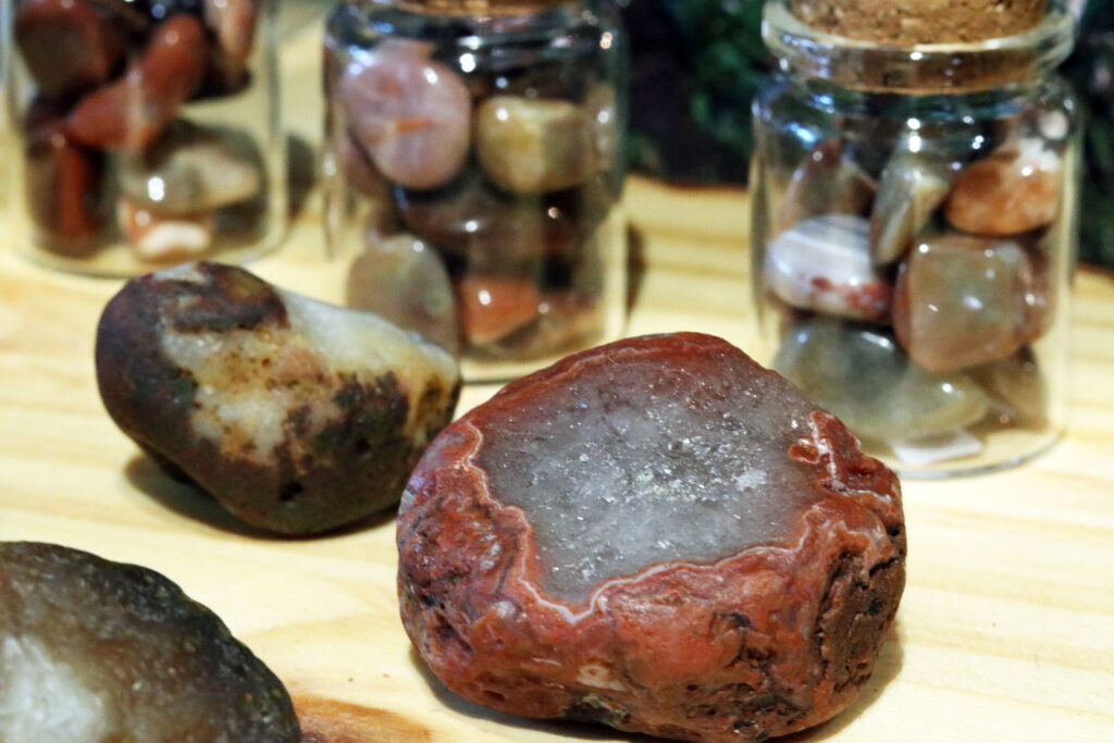 Lake Superior Agate specimen at Four Directions with vials of polished agate in the back.