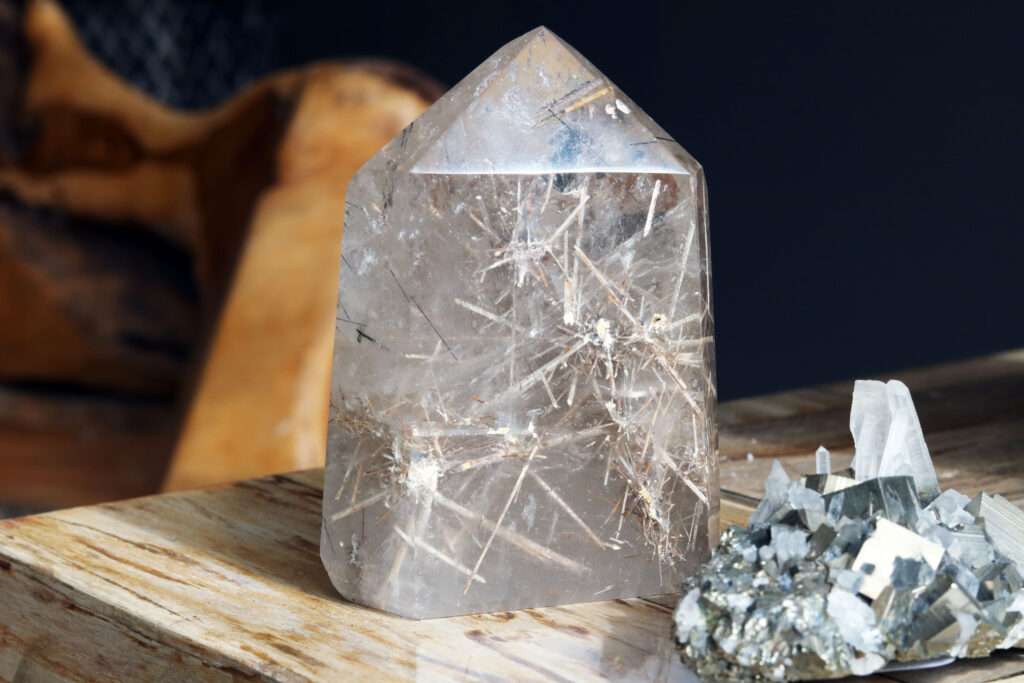 Rutilated quartz point specimen from Brazil next to a pyrite and quartz cluster from Peru.